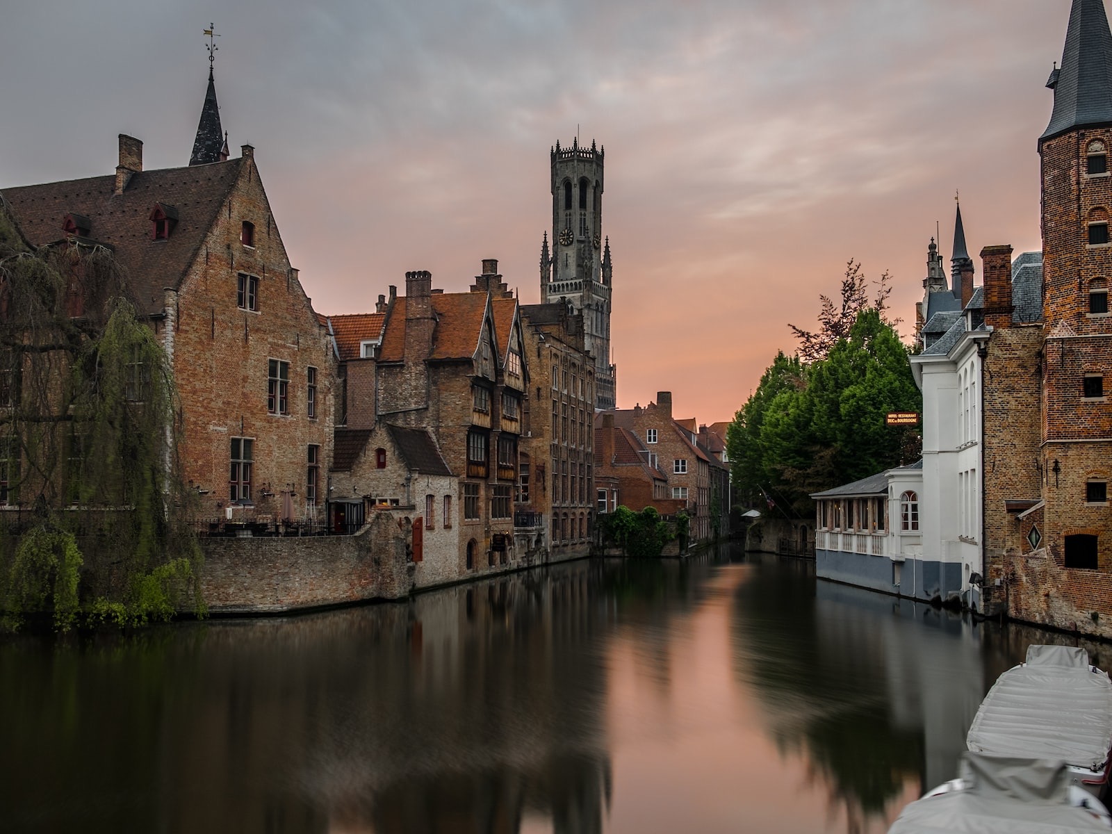 brown concrete buildings beside calm body of water